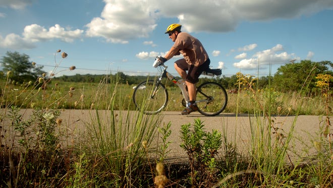A bicyclist takes a ride on the bike path along Pleasant Valley Road.