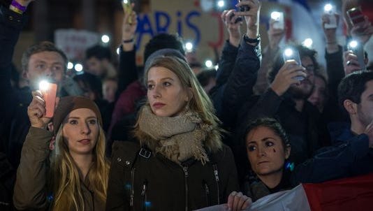 People in London, England, hold candles at a vigil for victims of the Paris terrorist attacks.