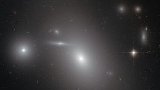 This image shows the elliptical galaxy NGC 4889 in front of hundreds of background galaxies, and deeply embedded within the Coma galaxy cluster. Well-hidden from human eyes, there is a gigantic supermassive black hole at the centre of the galaxy.