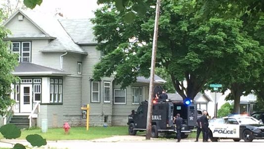 Green Bay police officers, including the SWAT team, wait outside a multifamily home at 904 N. Chestnut Ave. in Green Bay, where they apprehended a 40-year-old Green Bay man after a standoff of more than two hours Tuesday night.