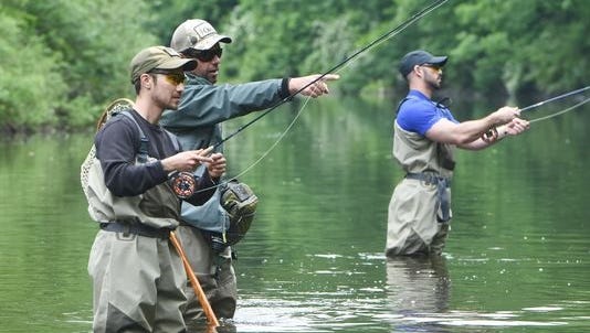Veterans William "T.J." Spiak Jr., left, and Marc Coviello, right, go fly fishing in Wappinger Creek near Route 44 in Pleasant Valley last June.