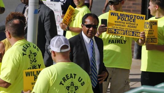 Wilmington Mayor Dennis P. Williams walks past protesting police officers to a mayoral debate on Aug. 17. The City Council on Thursday approved a new contract.