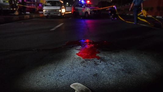 Blood left on an avenue after a shooting on Nov. 15, 2016, in Pasay, Philippines.