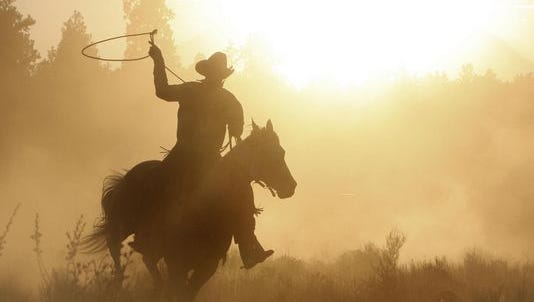 Cowboy roping on his horse silhouette.