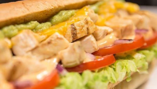 A Subway chicken sandwich with guacamole.