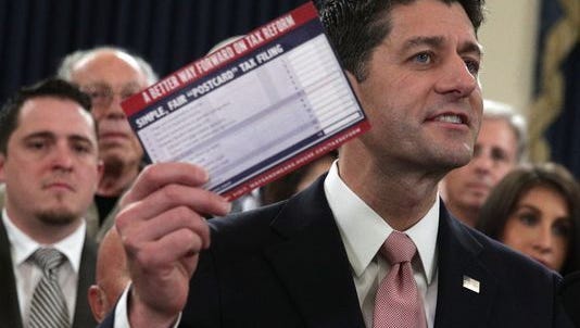 ouse Speaker Paul Ryan holds a sample postcard-size tax return form on Nov. 2.