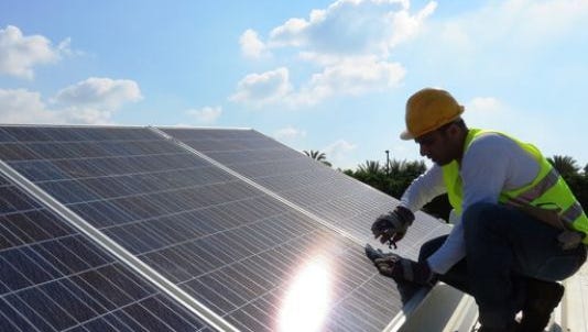 A worker installs solar system on a roof in this undated photo.