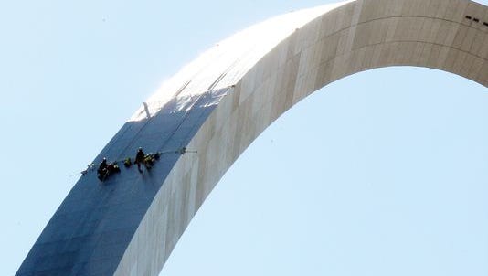 An engineering team rappels down the north leg of the Gateway Arch to collect samples of stains on the monument in St. Louis on October 16, 2014. The Arch, which is nearly 50 years old has recently developed dark stains on the legs resembling rust.