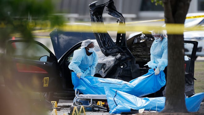 Personnel remove the bodies of two gunmen Monday, May 4, 2015, in Garland, Texas. Police shot and killed the men after they opened fire on a security officer outside the suburban Dallas venue, which was hosting provocative contest for Prophet Muhammad cartoons Sunday night, authorities said.