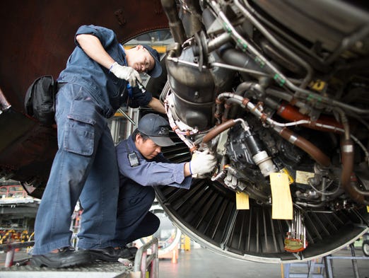 Mechanics work on a engine of a Boeing 747 inside
