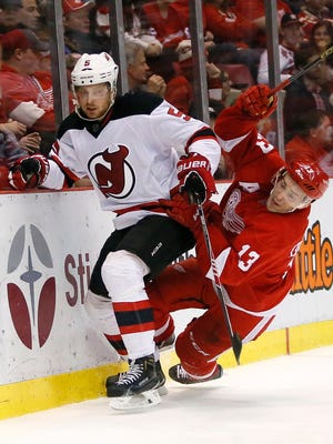 New Jersey Devils' Adam Larsson (5) avoids Detroit Red Wings' Pavel Datsyuk (13), of Russia, hitting the boards during the second period of an NHL hockey game at Joe Louis Arena Tuesday, Dec. 22, 2015, in Detroit.