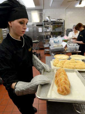 Bailee McCall puts a loaf of bread she made next to pastries, and a pineapple pie she made Thursday, March 15, 2018, in the culinary arts class kitchen at Stanbery Career Technology and Vocational Campus in Lancaster.