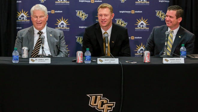 New UCF NCAA college football coach Scott Frost, center, is flanked by school president John C. Hitt, left, and athletic director Danny White during a news conference to introduce the new coach in Orlando, Fla., Wednesday, Dec. 2, 2015.