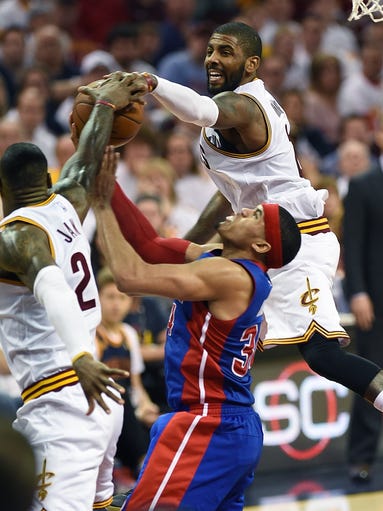 Cavs' LeBron James (left) and Kyrie Irving block a