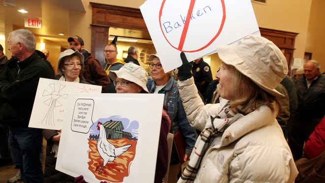 Protesters Linda Quinn (front to back), Barbara Schlachter, and Deb Schoelerman wave signs before an informational meeting on the Dakota Access pipeline project Dec. 1 in Fort Madison, Iowa. The Iowa City residents are members of the group 100 Grannies for a Liveable Future.