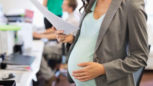 Pregnant businesswoman working in office.