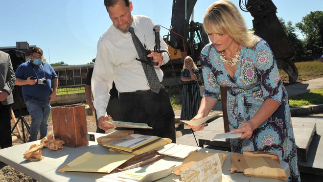 Weymouth Mayor Robert Hedlund and Weymouth Superintendent of Schools Jennifer Curtis-Whipple look at items found in a time capsule that was buried in 1963 when the former Weymouth North High School - later renamed the Maria Weston Chapman Middle School - was opened that is now being demolished for a new middle school during a groundbreaking ceremony on Thursday, July 2, 2020.