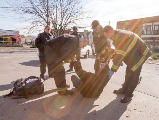 A man is helped off the ground, suspected of being