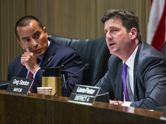 Phoenix City Councilman Daniel Valenzuela, left, listens