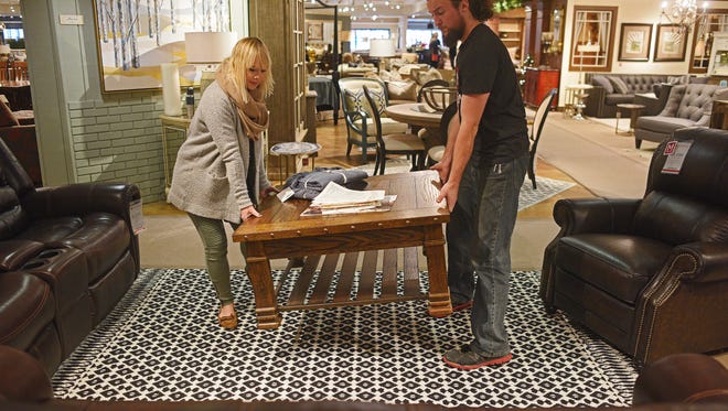 Karli Strain, left, a visual merchandiser with Montgomery's, and Grady Wirth, also with Montgomery's, work on a furniture display at Montgomery's in Sioux Falls.