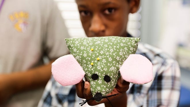 Daniel Helaire holds up a handmade pin cushion during the grand opening of The Little Shop on Orange Street, an entrepreneurial school program in which students will manufacture, market and sell products, at Paul Breaux Middle School in Lafayette, La., Tuesday September 5, 2017.
