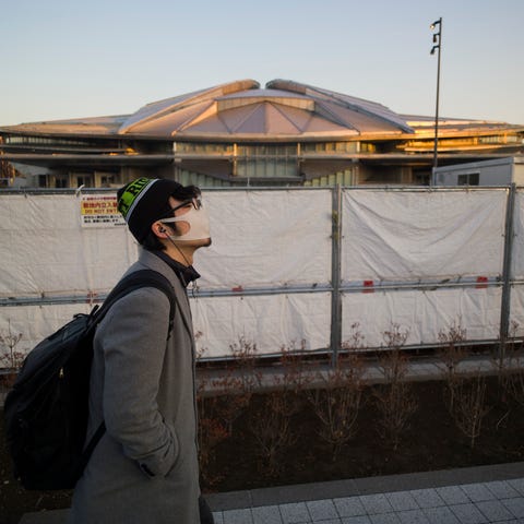 A man walks past the closed Tokyo Metropolitan Gym