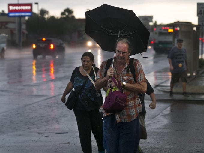Jay Jones of Phoenix tries to stay dry under heavy