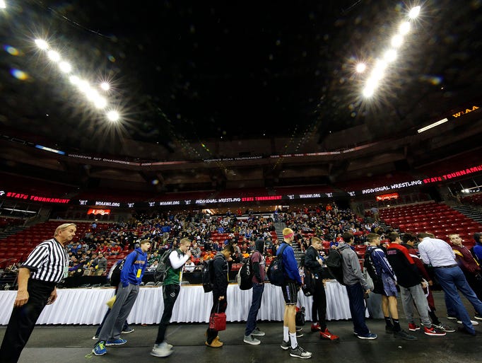 Division 1 wrestlers wait to weigh in before the start