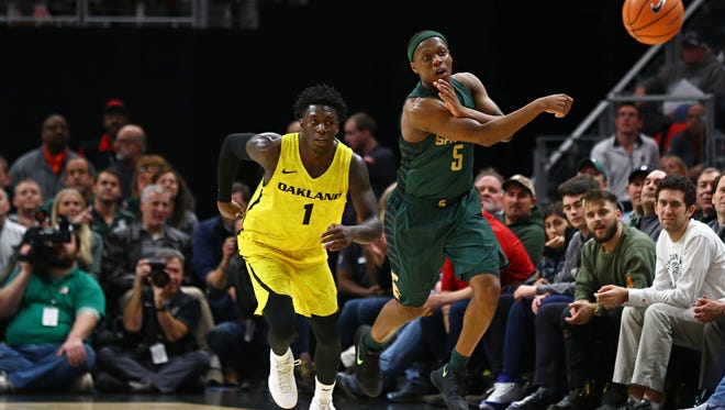 Oakland Golden Grizzlies guard Kendrick Nunn (1) defends as Michigan State guard Cassius Winston passes the ball up the court in the first half Saturday at Little Caesars Arena.