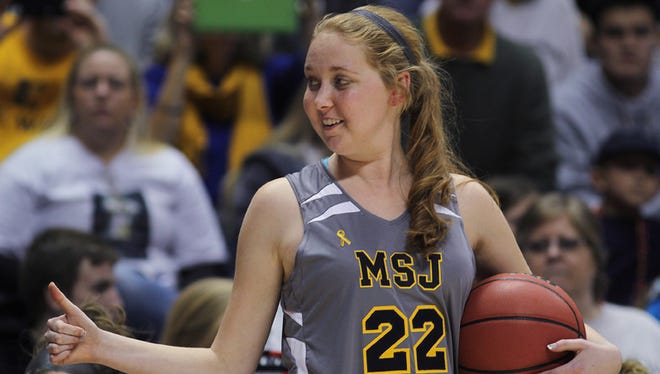 Mount St. Joseph's Lauren Hill gives thumbs up as she holds the game ball during her first NCAA college basketball game against Hiram University at Xavier University in Cincinnati, Sunday Nov 2, 2014. The NCAA allowed Mount St. Joseph's season opener to be moved up to Nov. 2, so that Hill, who has an inoperable brain tumor, to be able to play in a college basketball game. (AP Photo/Tom Uhlman)
