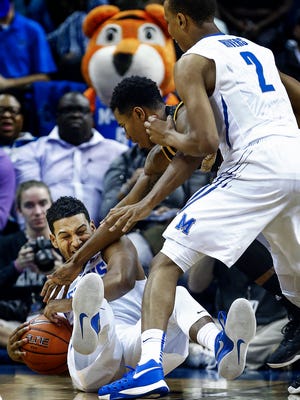 University of Memphis guard Christian Kessee (left bottom) grabs a loose away from Milwaukee guard Jeremiah Bell (middle) as teammate Jimario Rivers (right) looks on during first half action at FedExForum. 