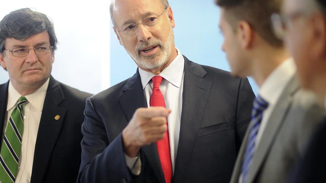 Pennsylvania Gov. Tom Wolf, center, talks with State Representative Mike Carroll, left, State Representative Eddie Day Pashinski , right, and Michael Clemente, regional director, American Income Life — Simon Arias Agenices, Wilkes-Barre, at the Simon Arias Agencies,in Wilkes-Barre, Pa., Thursday, March 31, 2016. Earlier this month, as part of his “Jobs That Pay” initiative, Gov. Wolf signed an executive order that ensures employees under the governor’s jurisdiction will be paid no less than $10.15 an hour. Wolf is now calling upon Pennsylvania legislators to pass a minimum wage increase for all Pennsylvania workers. (Mark Moran/The Citizens' Voice via AP)