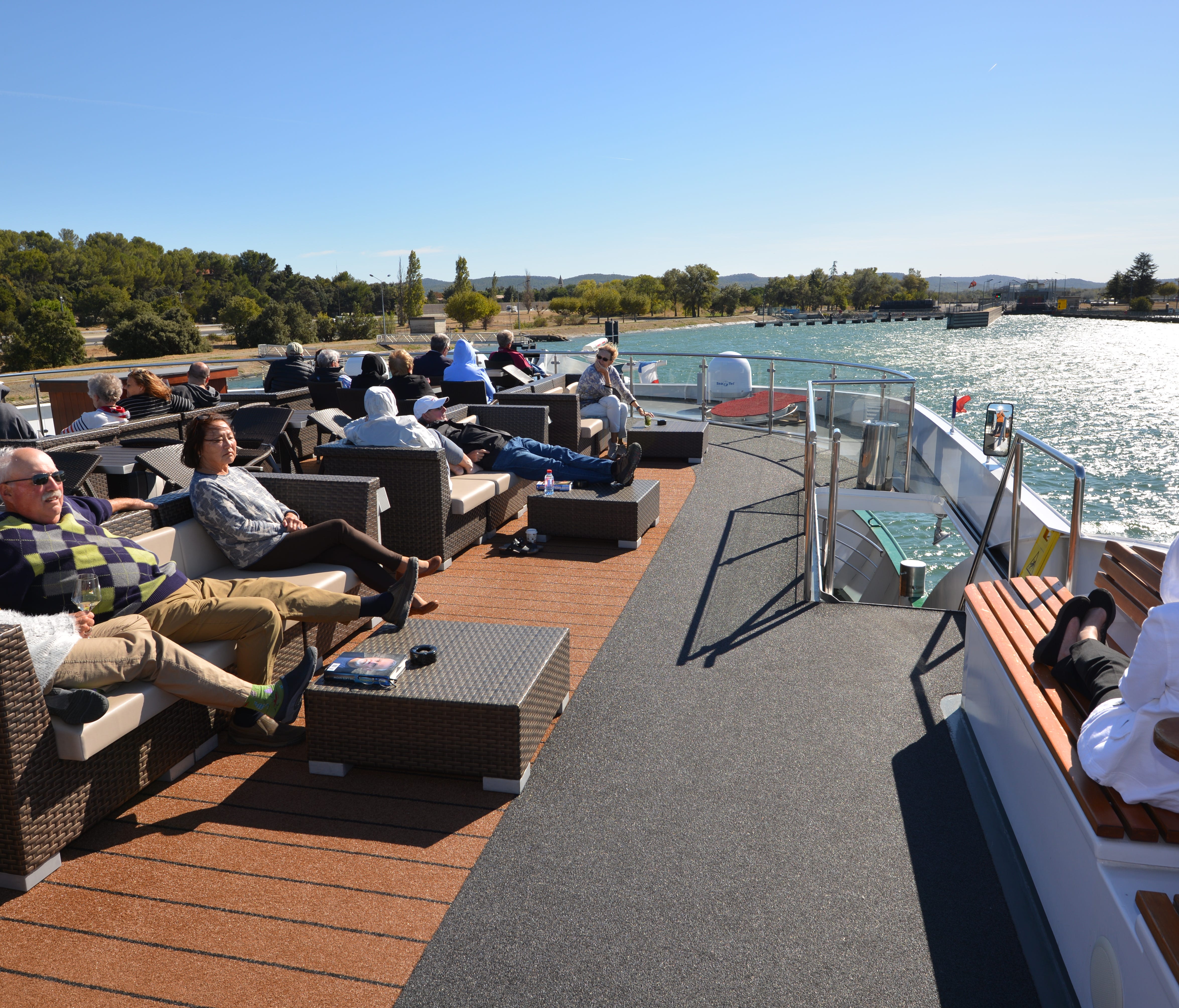 Emerald passengers look out over the Rhone River from the front of the ship's top deck.