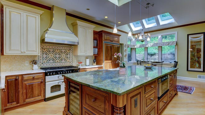 Furniture-quality cabinets, a 11-foot green-granite center island, gold marble                                                 cabinet counters and 11 skylights make this kitchen unique.
