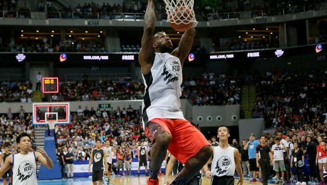 NBA basketball player LeBron James of the Cleveland Cavaliers executes a slam during an exhibition game with a select group of Filipino players at the launch of a Nike sponsored television program Thursday, Aug. 20, 2015 at the Mall of Asia Arena at suburban Pasay city south of Manila, Philippines.