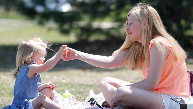 Veada Mueller and her mother Natasha Mueller share a picnic Saturday  in Lakeside Park as they enjoy the warmer weather.  Temperatures are expected to be pleasant all week.