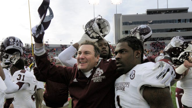 Mississippi State coach Dan Mullen, celebrates Mississippi State's 24-17 overtime victory over Arkansas with defensive back Nickoe Whitley (1) after the NCAA college football game in Little Rock, Ark., Saturday, Nov. 23, 2013. (AP Photo/David Quinn)