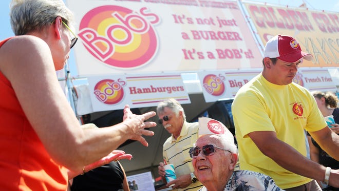 Bob Corey celebrates the first day of the 149th-annual Oregon State Fair at his namesake burger stand greeting people such as Theresa Thomson, who worked at Bob's as a McNary student starting in 1969.