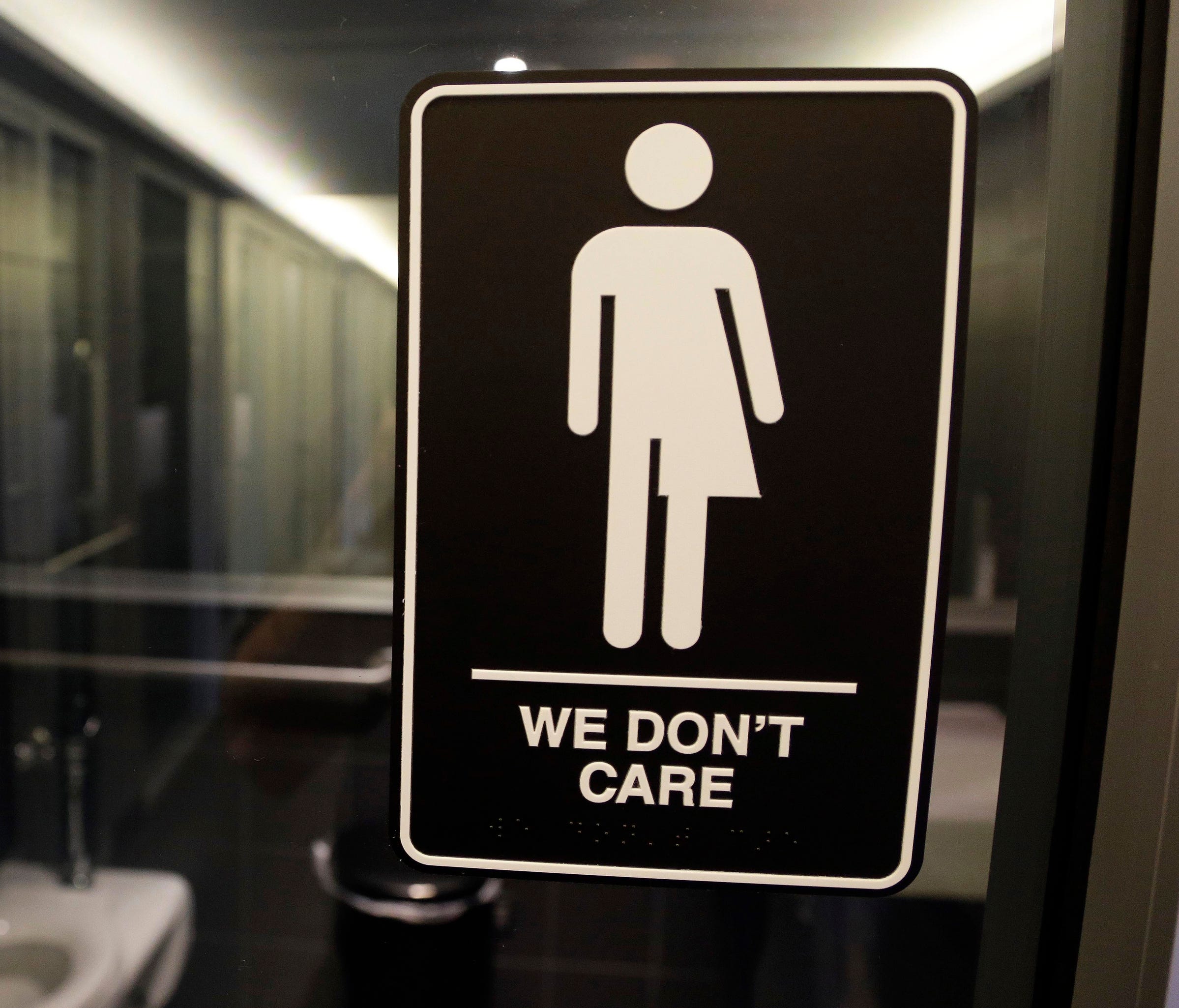 Signage hangs outside a restroom at 21c Museum Hotel in Durham, N.C.