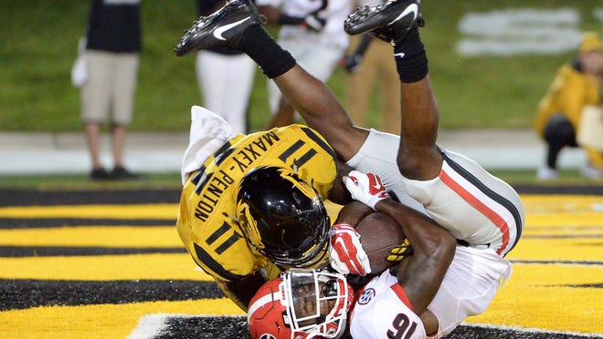 Georgia Bulldogs wide receiver Isaiah McKenzie (16) catches a touchdown pass as Missouri Tigers defensive back Aarion Maxey-Penton (11) defends late in the fourth quarter Saturday night. The catch and point after put the Bulldogs ahead 28-27.