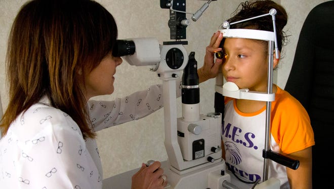 Dr. Dawn Heffelfinger, examines Lizeth Ochoa's, 11, eyes,  as part of a program called Eye Care 4 Kids at Butler Elementary, on February 27, 2015, in Phoenix. Eye Care 4 Kids is a mobile unit that launched it's first day in operation in Arizona today.
