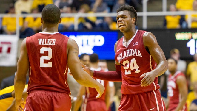 Oklahoma Sooners guard Buddy Hield (24) talks to guard Dinjiyl Walker (2) during the first half against the West Virginia Mountaineers at the WVU Coliseum.
