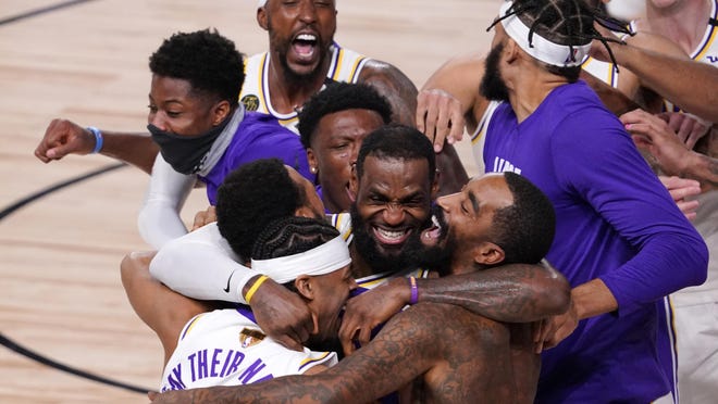 Los Angeles Lakers' LeBron James (23) celebrates with his teammates after the Lakers defeated the Miami Heat 106-93 in Game 6 of basketball's NBA Finals Sunday in Lake Buena Vista, Fla.