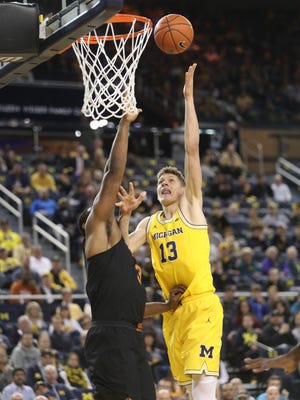 Michigan forward Moritz Wagner scores against Texas forward Shaquille Cleare during the first half Tuesday at Crisler Center.