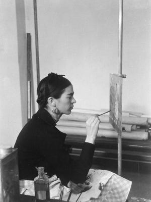 Frida Kahlo works in 1932 on “Self-Portrait on the Borderline between Mexico and the United States,” painted in Detroit.
