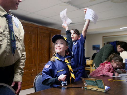 Brianna Richie and Sydney Taylor, both 8, celebrate completion of a project assignment during a recent Cub Scout meeting.