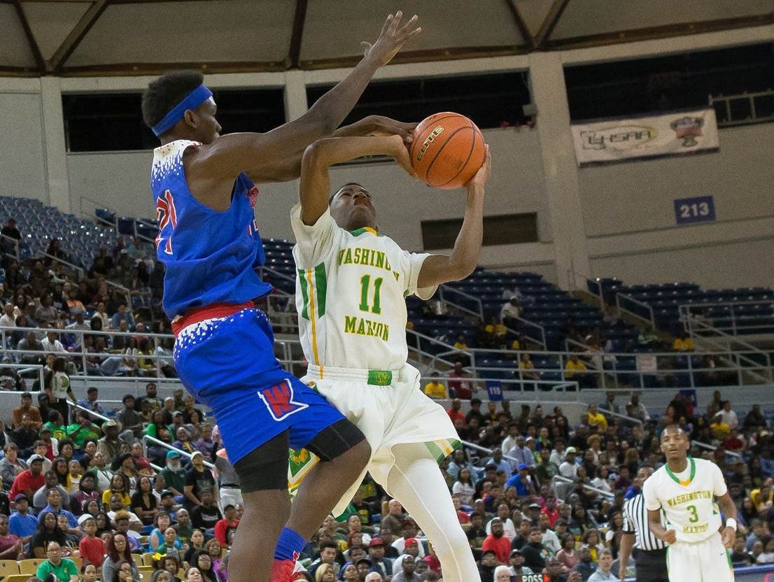 Woodlawn's DeVante' Brooks tries to block the shot of Washington-Marion's Cody Stansberry Thursday at Burton Coliseum.