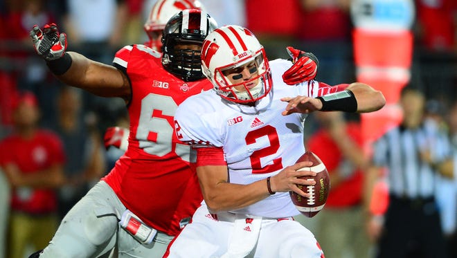 Wisconsin Badgers quarterback Joel Stave (2) is sacked by Ohio State Buckeyes defensive lineman Michael Bennett (63) during the third quarter at Ohio Stadium in 2013. The two teams meet again Saturday in the Big Ten championship game.