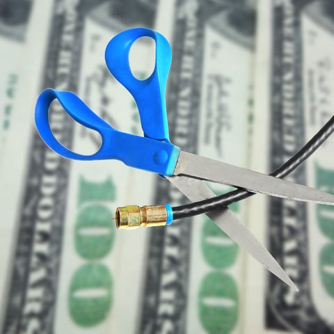Scissors cut a cable in front of cash