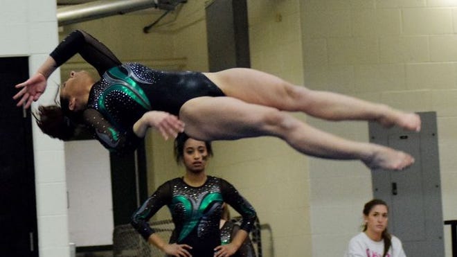 Crystal Kratzer of Mason makes an air somersault work during her floor routine for the Comets in the district gymnastic meet, helping Mason head to state.